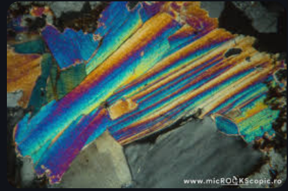 <p>colorless to weak, 1 basal cleavage plane, no pleochroism, low relief, 2nd-3rd order birefringence, parallel extinction, and fine twinning.</p>