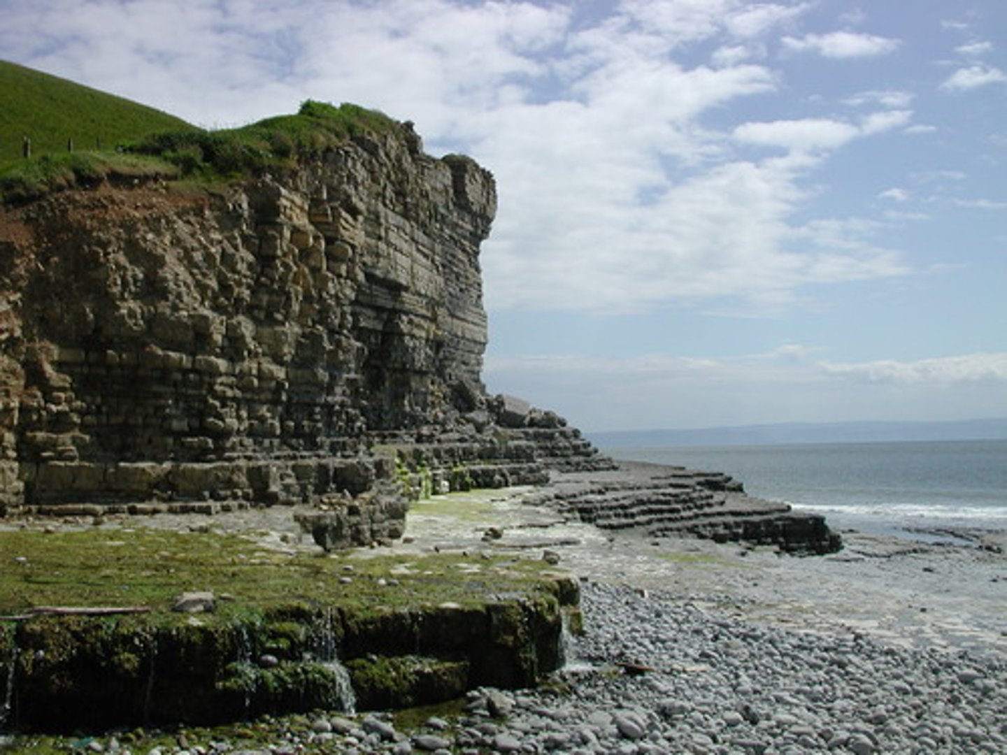 <p>klif, urwisko - a high, steep rock face</p>