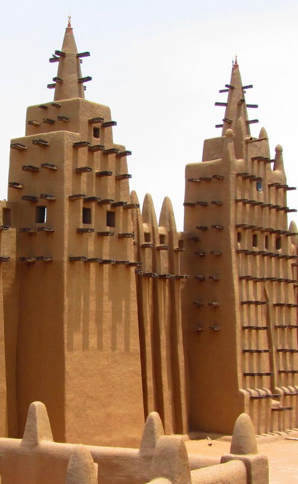 <p>Vertical wooden beams protruding from the facade of mud-brick structures, often seen in West African architecture, providing structural support and aesthetic appeal. </p>