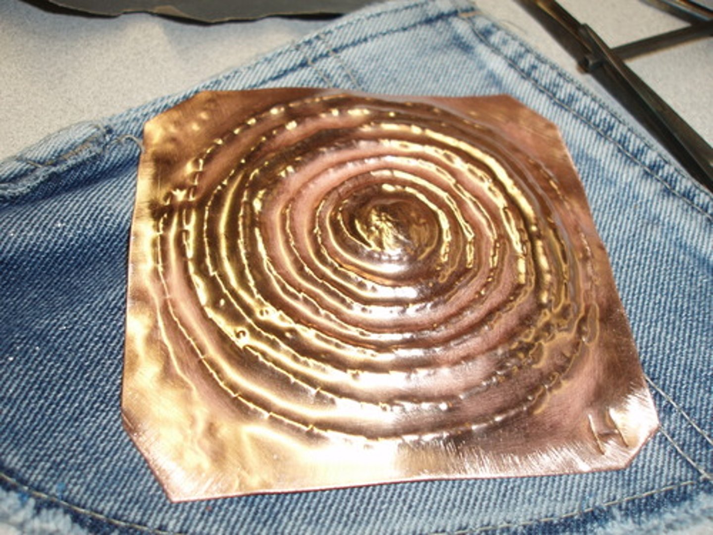 <p>a type of metal relief sculpture in which the back side of a plate is hammered to form a raised relief on the front</p>