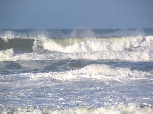 Large waves that carry sand and other material away from the shore and erode the beach. 