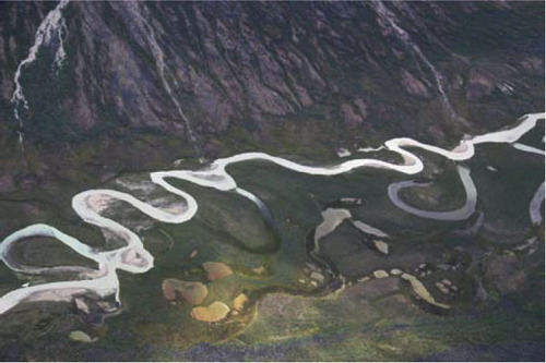 a river flows down a steep slope into a flat valley