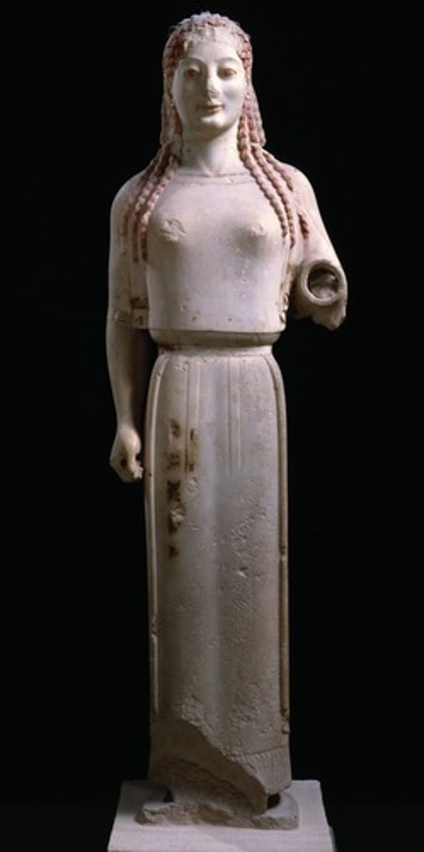 <p>Form:</p><p>-archaic smile</p><p>-patterned hair</p><p>-marble with paint remains</p><p>-smaller scale</p><p>Content:</p><p>-women with arm out (supposed to hold out a oil lamp but hand broken off)</p><p>Function:</p><p>-in front of temples to "light the way"</p><p>-votive figure</p><p>Context:</p><p>-530 BCE</p>