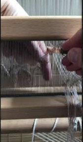 <p>Taking the warp ends through the dents of the reed at the desired density</p>