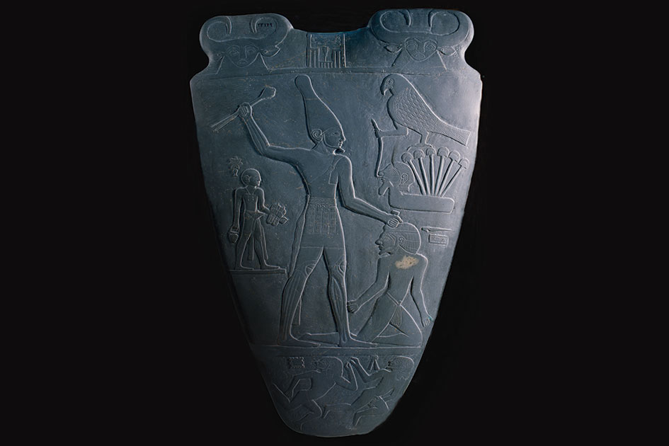 One of the earliest hints of hieroglyphic writings and show cases a hierarchy of scale with the King Narmer being the largest figure. 