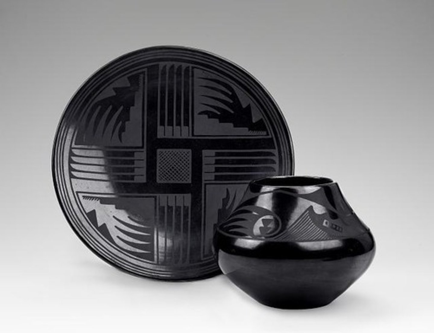 <p>Maria and Julian Martinez, tribal members of San Ildefonso Pueblo, Tewa, Maria shaped and fired the clay and Julian painted 2D designs, best known for black on black ware, before was colorful with off-white backgrounds and designs in black/reddish-brown, Maria coated them in slip before firing, shiny stuff, reframed art vs. craft, signed pots</p>