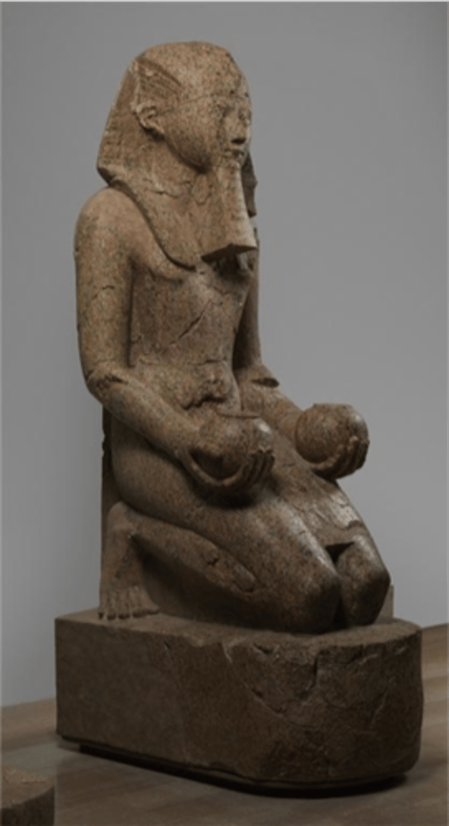<p>Period: New Kingdom</p><p>Subject: Queen-turned-pharaoh Hatshepsut</p><p>Medium: Life-sized carved granite</p><p>Features: Kneeling figure with spherical pots, wearing kilt and false beard</p><p>Context: One of dozen identical statues lining processional route to Mortuary Temple at Deir el-Bahri</p><p>Historical Significance: Represents powerful female ruler who became co-ruler of reunified Egypt</p><p>The kneeling statue of Hatshepsut was important because it legitimized her rule as a female pharaoh by depicting her with traditional male iconography (the false beard and nemes headdress)</p>