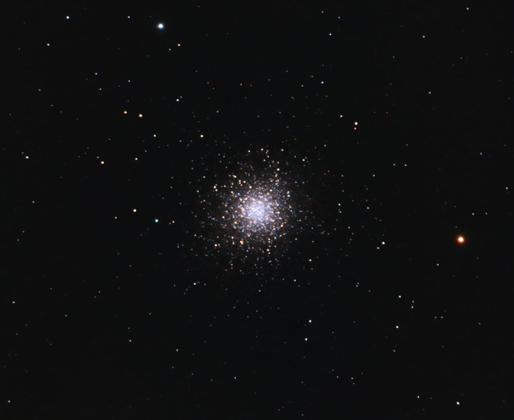 Globular clusters appear as fuzzy, circular patches of light in binoculars. In telescopes, more of the stars towards the centre of the cluster can be identified. 

An example would be the Great Globular Cluster in Hercules (M13).