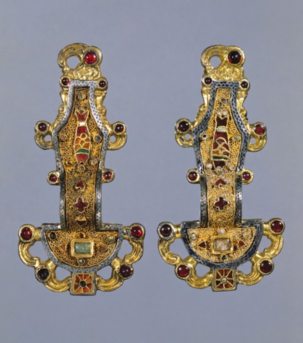 <p>Early medieval Europe. Mid-6th century C.E. Silver gilt-worked in filigree, with inlays of garnets and other stones.<br><br>Zoomorphic elements (eagle and fish). A fibula is used as a pin or a brooch to fasten garments; Showed the prestige of the wearer. Generally symmetrical. Northern jewelers carefully crafted their molds to produce a glittering surface on the cast metal.</p>