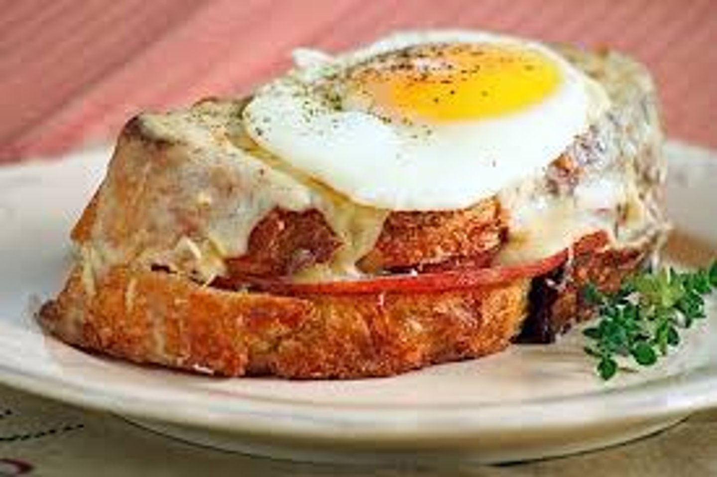 <p>a grilled ham and cheese sandwich with a fried egg on top</p>