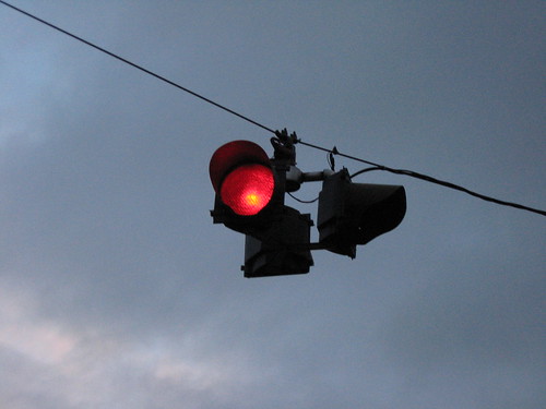 <p>Light at the stop light which means stop. Wait behind the stop line on the carriageway</p>