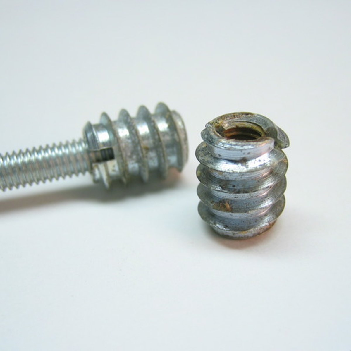 <p>metal inserts with threads that protect the wood or board's screw slot</p>