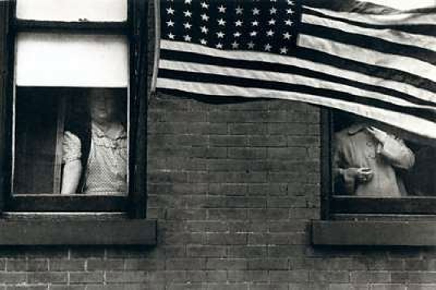 <p>Photographs of streets and people. The book was called The American and featured people in windows next to a flag. Also had a famous photograph that he took of people looking out of a train.</p>