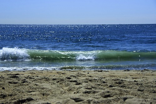 Waves that carry and deposit sand and other materials and build up a beach.