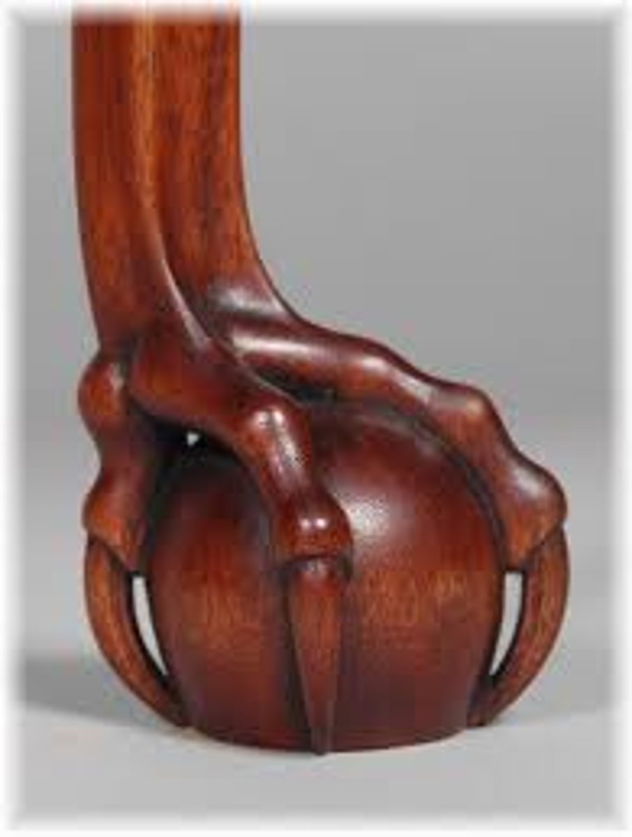 <p>A carved lions or birds claw clutching a sphere, usually at the end of a cabriole leg or tables base.</p>