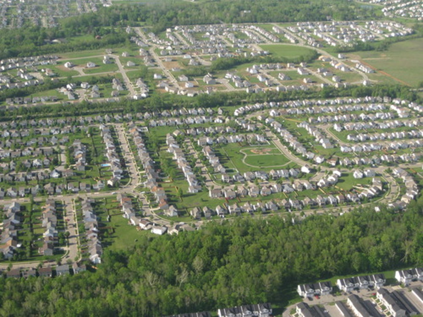 <p>An area on the outskirts of the city center that is residential (dedicated to housing). / The movement of people from the urban core areas to the surrounding outskirts where land is more plentiful, and prices are cheaper.</p>
