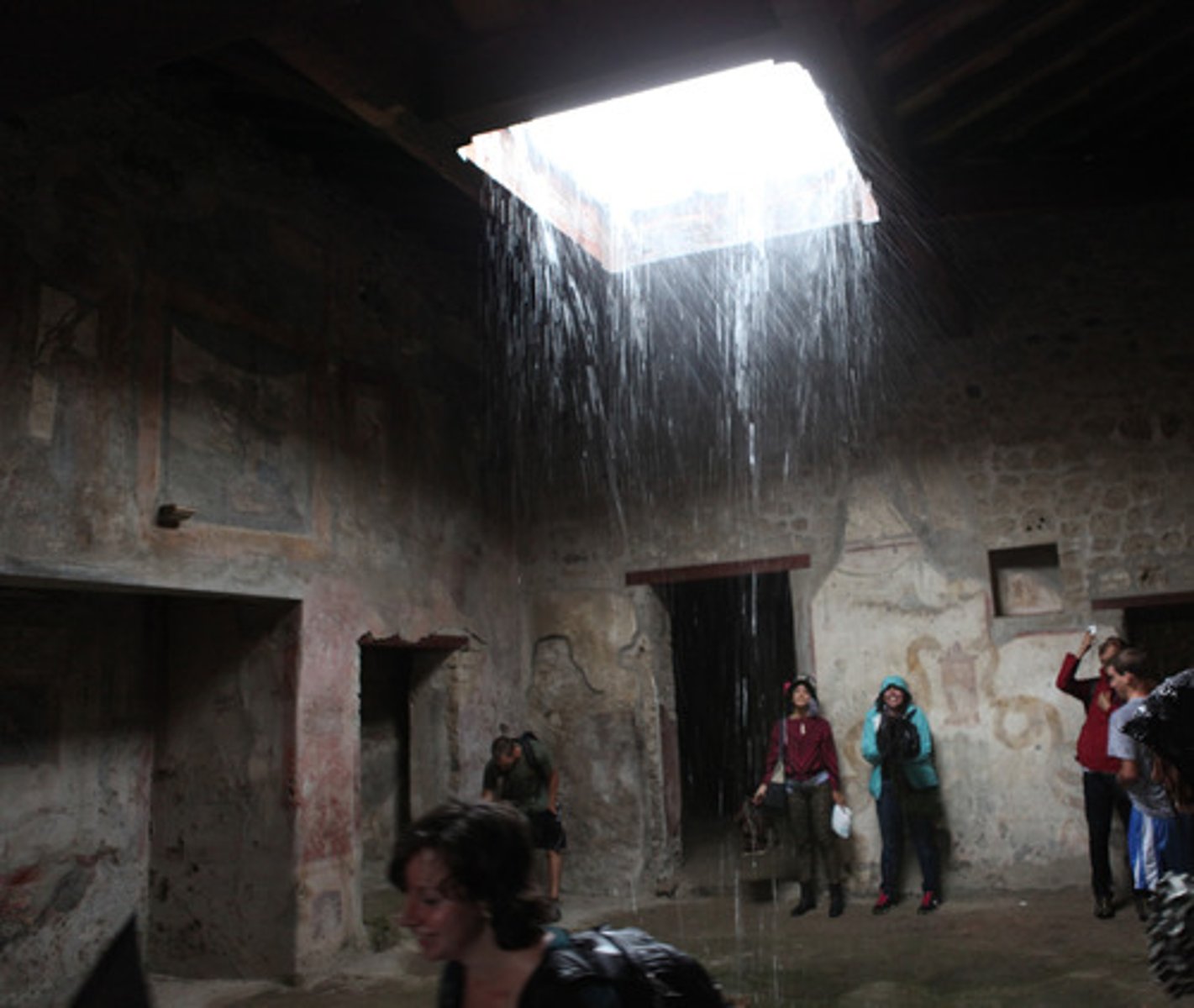 <p>a square opening in the roof of the ancient Roman atrium toward which the roof sloped and through which the rain fell into the impluvium</p>