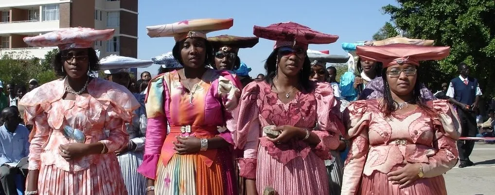 <p>Traditional Namibia dress</p><ul><li><p>inspired by victorian era dresses &amp; forced into Namibia culture by colonizers</p></li><li><p>has head piece goes with it reprsenting cow horns </p></li></ul><p></p>