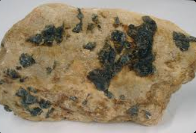 <p>is a texture in igneous rocks characterized by very large mineral grains, often forming in the late stages of magma crystallization. </p>