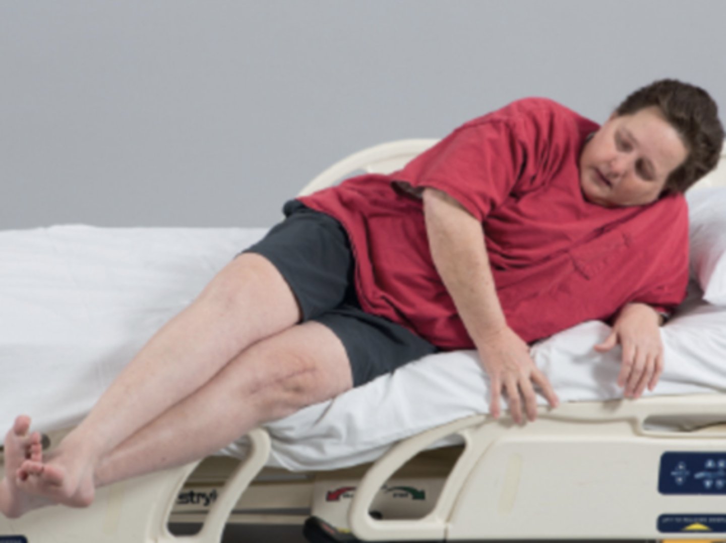 <p>This patient has hooked her left ankle under the ankle of her weak right leg and is using the strength of her left leg to lift both legs up onto the bed.</p><p>The same technique can be used when moving from sidelying into sitting.</p>