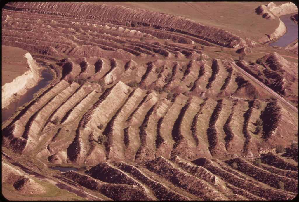 <p>• types of surface mining</p><ul><li><p>Earth movers strips away overburden and  giant shovels removes mineral deposit</p></li><li><p>often leaves highly erodible hills of rubble called spoil banks</p></li></ul>