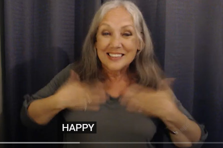 take both hands and pat twice upwards on the chest while smiling  