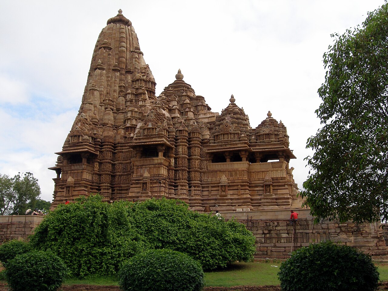 <ul><li><p>Temple of the Chandela Dynasty </p></li></ul><ul><li><p>Located at Khajuraho </p></li><li><p>It is the greatest masterpiece of the Chandela, surpassing the smaller temples built by the dynasty prior to it </p></li><li><p>It was built in fine cream-colored sandstone</p></li><li><p>Its phallic spire rises for 116 feet, though it appears even higher because of the deep basement and the vertical lines on the spire, surrounded by lesser spires </p></li><li><p>Inside the Temple is a Pradaksina, or walkway, provided with shaded balconies </p></li><li><p>At the lower levels of the Temple, depictions of scenes from hunting, warfare, and courtly life are depicted </p></li><li><p>At the higher levels of the Temple, friezes depict representations of gods and goddesses, along with scenes of lovemaking, depicting couples and trios indulging in all the erotic variety which the vivid imagination of the gods had ordained </p></li></ul><p></p>
