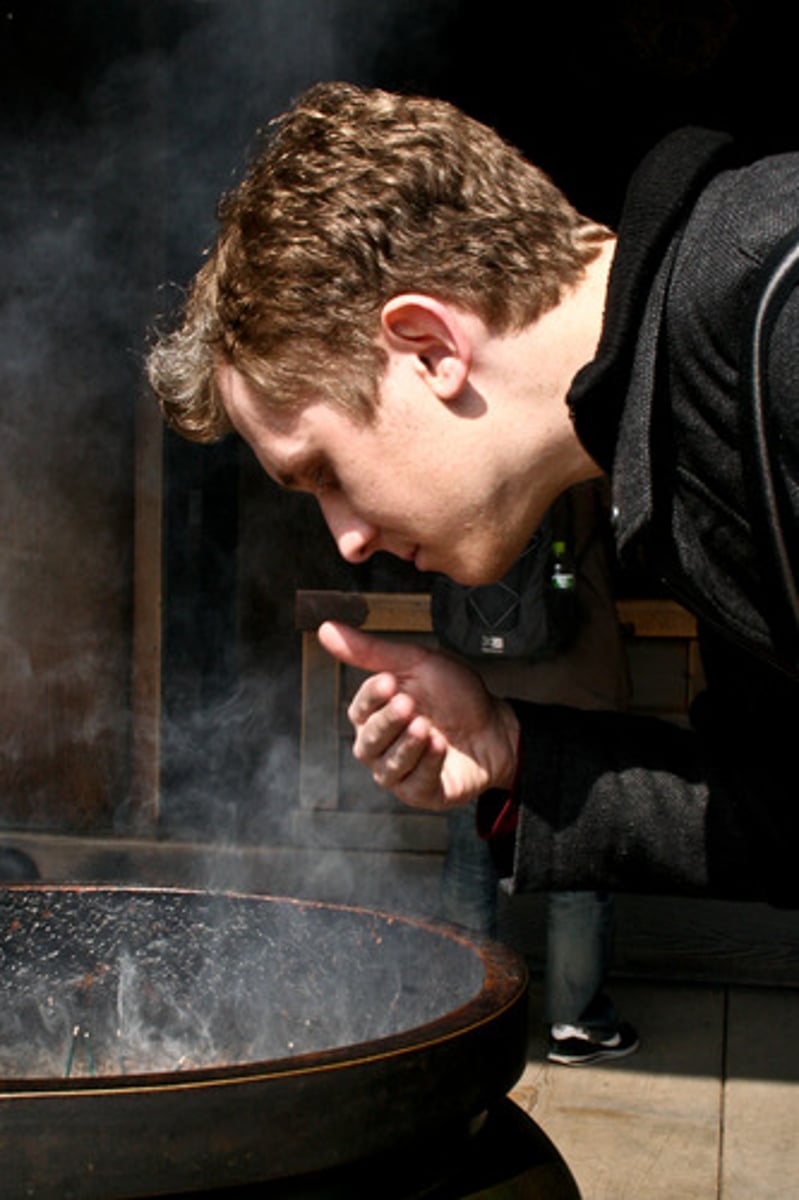 <p>Using your hands to direct fumes to your nose</p>