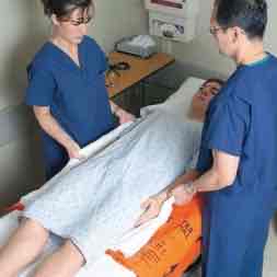 <p>What is the orange object underneath the patient?</p>