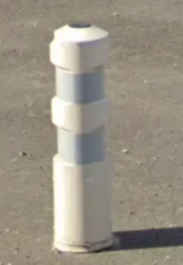 <p>White bollard with reflectors</p>