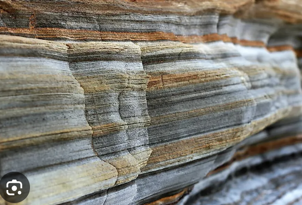 <p>Formed from layers of pre-existing rocks or organic material that accumulate on the Earth's surface and are compacted and cemented together</p>