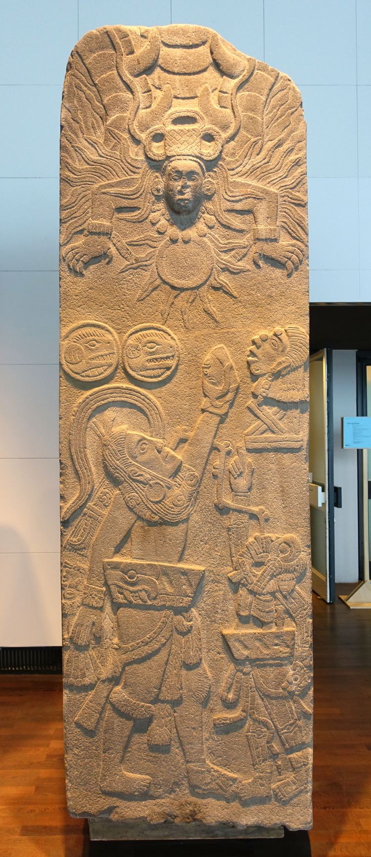 <p>Late Classic. Depicts a ball player and death god, both in ballgame yokes, standing in front of a temple. They reach toward a scorpion sun to offer a human heart.</p>