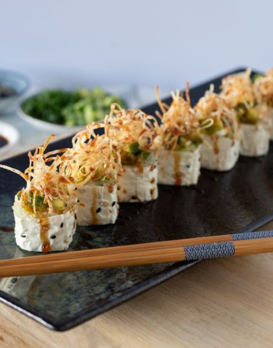 <p>base roll: mango, avocado, sushi rice, soy paper</p><p>yuzu tamari dressing, vegan mayo, crispy taro, sushi sauce, green onion, sesame seeds.</p><p>100% PLANT BASED</p>