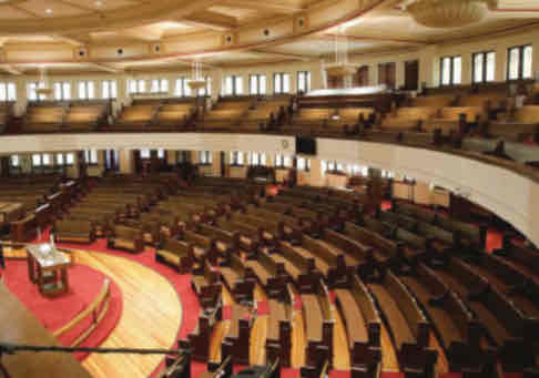 <p> features a rectangular school block and a semicircular</p><p>church auditorium. Inside, seats are arranged</p><p>amphitheater-style with an overlooking</p><p>balcony.</p>