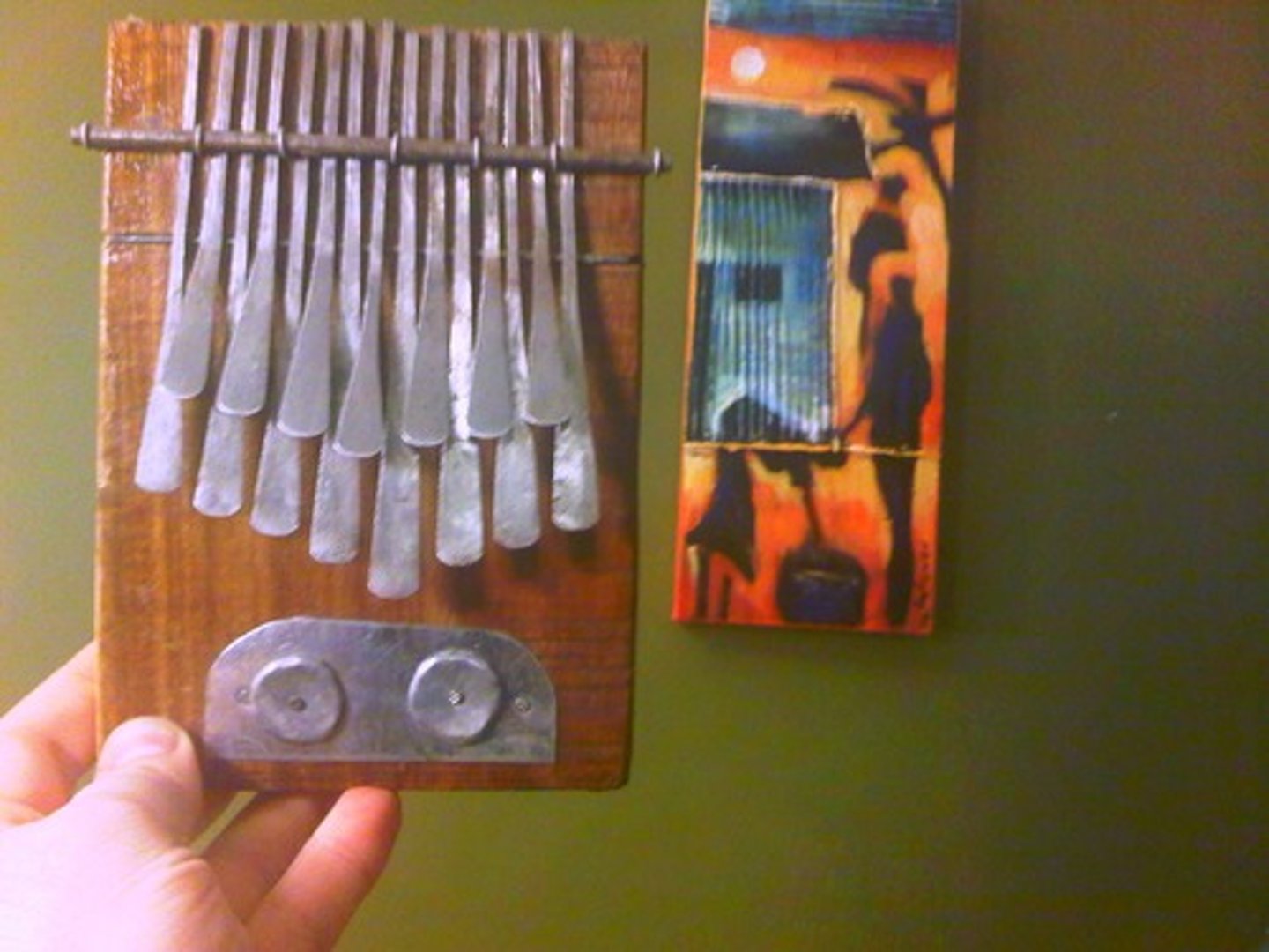 <p>Thumb-piano - wooden board with metal strips plucked with the thumbs.</p>