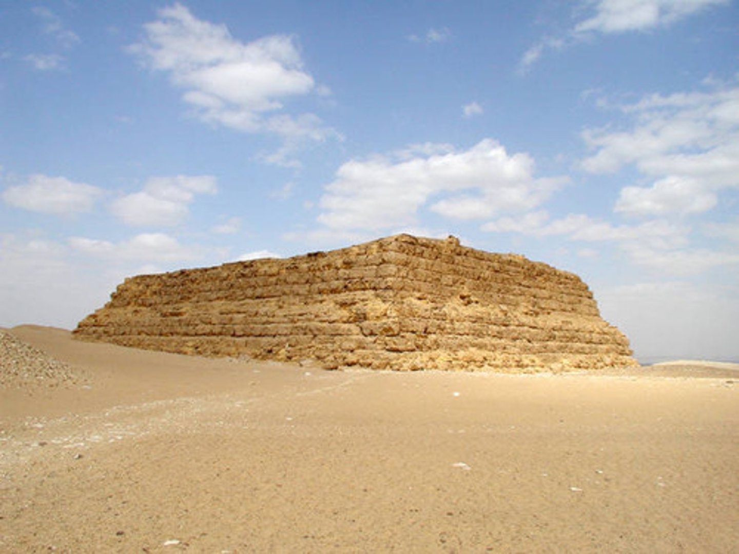 <p>Ancient egyptian brick or stone structure with sloping sides erected over a subterranean tomb chamber connected with the outside by a shaft</p>