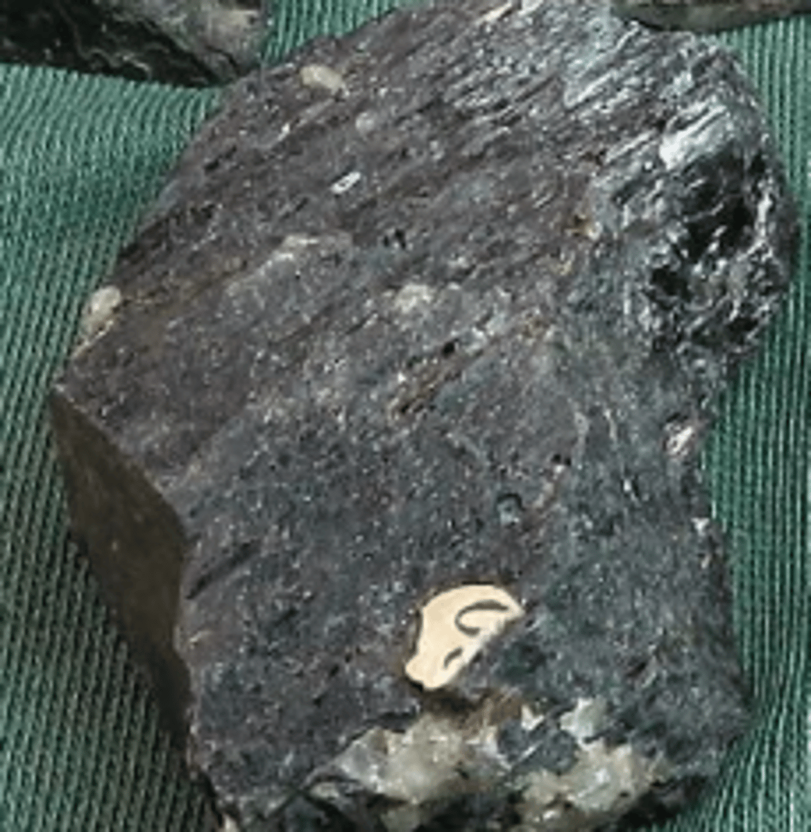 <p>Mafic Mineral (dark in color and high density) <br>high concentrations of some combination of iron, magnesium, calcium, and titanium. They tend to have low concentrations of silica, sodium, aluminum, and potassium</p>