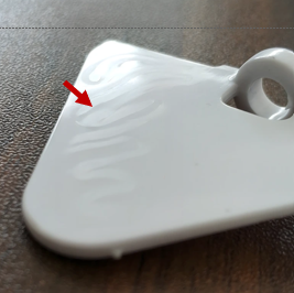 <p>surface defect in injection-molded parts that appear as wavy lines or color variations, caused by uneven material flow and differing cooling rates, which can impact aesthetics.</p>