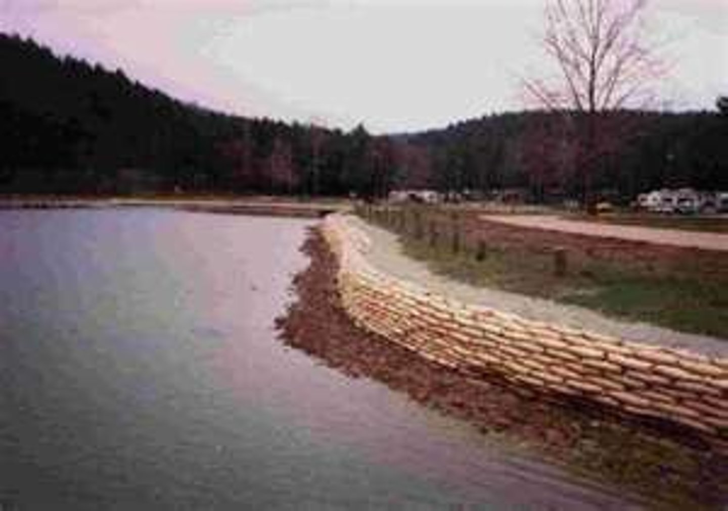 <p>Raised banks constructed along the river; they effectively make the river deeper so it can hold more water. They are expensive and do not look natural but they do protect the land around them</p>