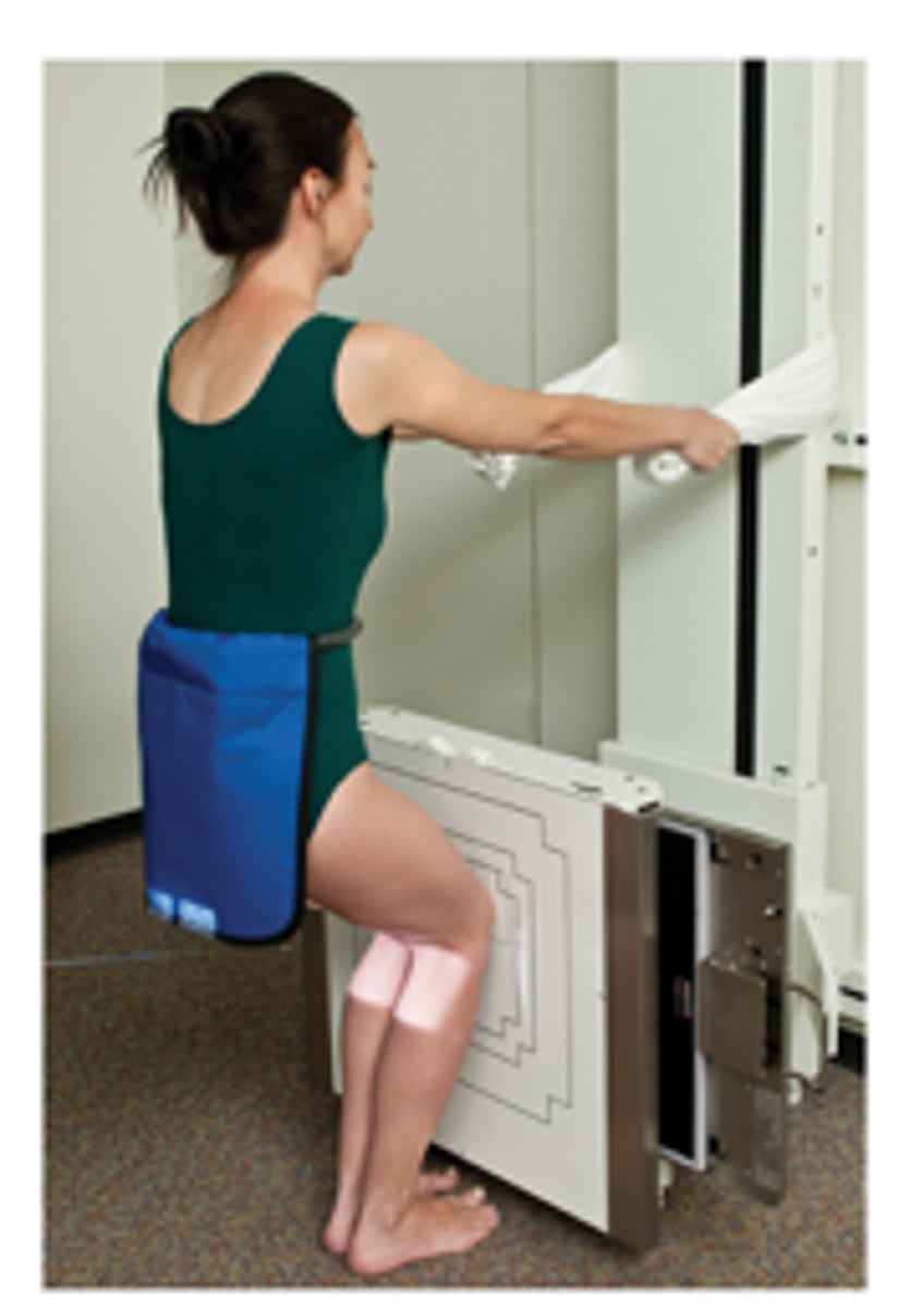 <p>1. The patient is weight-bearing in a PA position; patient to stand on a stool against the bucky.</p><p>2. Tibia should be touching &amp; parallel with the IR.</p><p>3. Rotate lower leg to ensure centralisation of the patella.</p><p>4. Patient to hold the bucky column and then sit/squat back. Encourage weight distribution to the joint being imaged.</p>