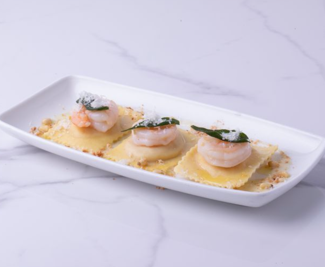 <p><span>Ravioli Filled With Creamy Mascarpone and Velvety Butternut Squash, Sauteed Prawns (sustainably harvested), Truffle Beurre Blanc (Truffle butter), Crispy Fried Sage, amareto cookie, grana padano cheese, toasted pine nuts.  </span></p><p></p>