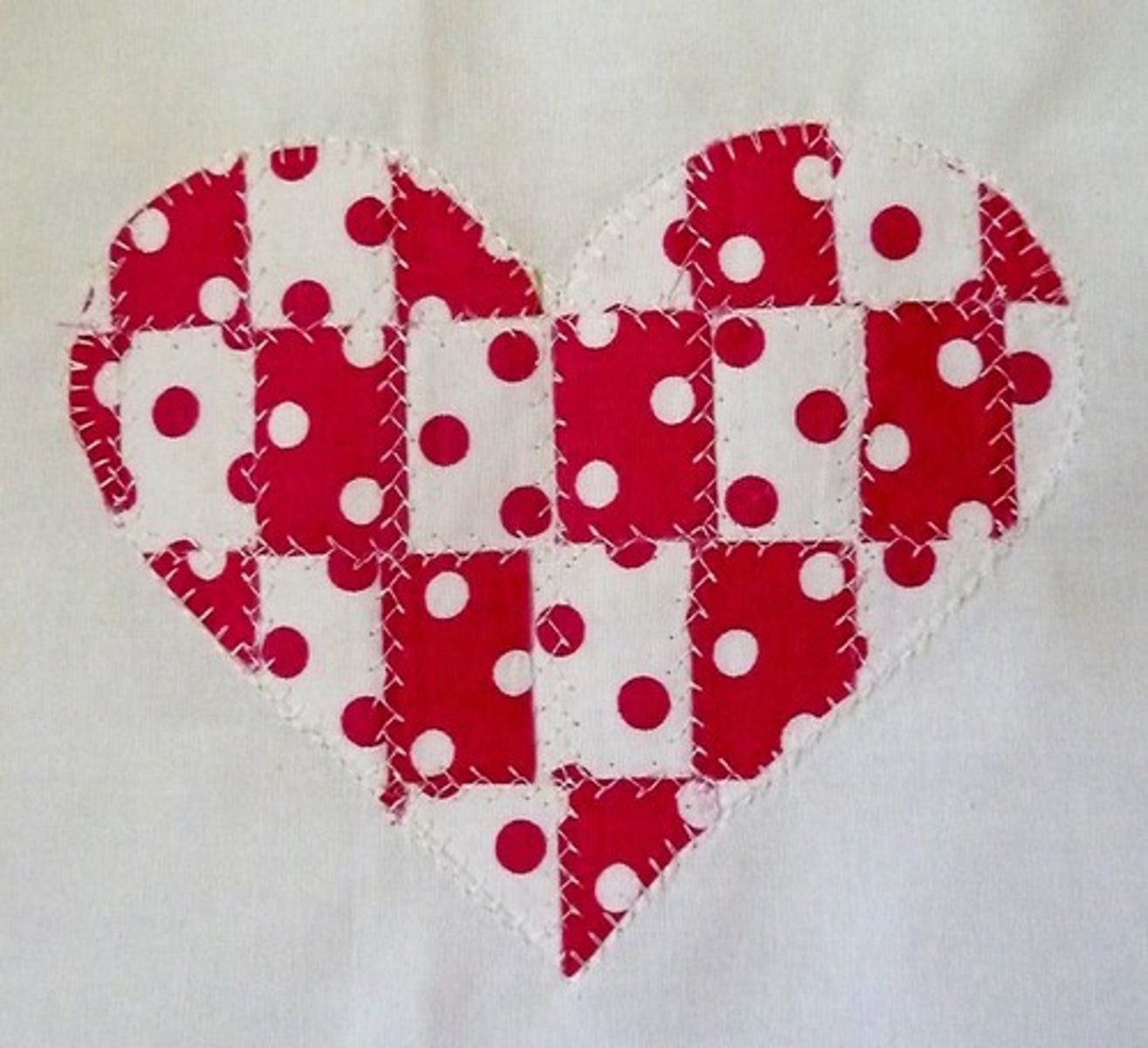 <p>An art form in which cutout fabric decorations are fastened to a larger surface to create a new design</p>