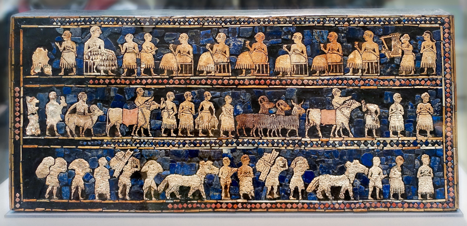 <p>A Sumerian artifact dating back to around 2600-2400 BCE, made of wood and inlaid with lapis lazuli, shell, and red limestone. It features scenes of war and peace, illustrating the social hierarchy and cultural practices of ancient Mesopotamia. Found in Royal Grave. Hierarchy of Scale. </p>