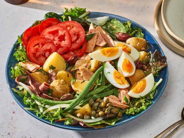 <p><span style="color: rgb(32, 33, 34)">is a salad that originated in the French city of Nice. It is traditionally made of tomatoes, hard-boiled eggs, Niçoise olives and </span>anchovies or tuna,<span style="color: rgb(32, 33, 34)"> </span>dressed<span style="color: rgb(32, 33, 34)"> with </span>olive oil<span style="color: rgb(32, 33, 34)">, or in some historical versions, a </span>vinaigrette<span style="color: rgb(32, 33, 34)">.</span></p>