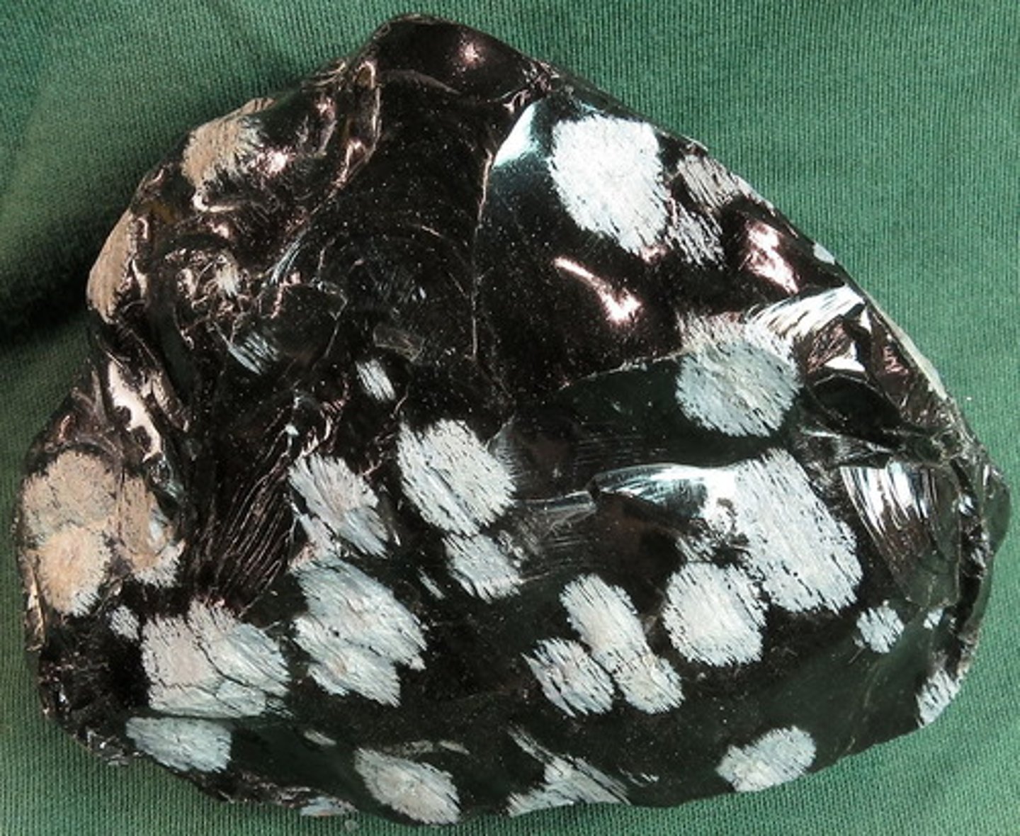 <p>Volcanic liquid that cooled so fast that it could grow few or no crystals, and so quenched to a glass. The white patches contain tiny, long, thin feldspar crystals that grew rapidly during cooling from the patch centers. (volcanic rock - quickly-cooled, fine-grained or glassy)</p>