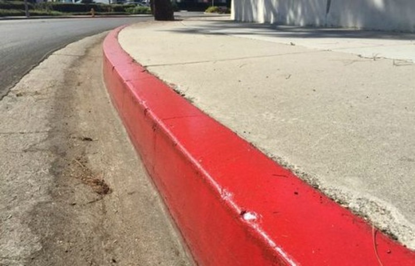 <p>Next to a red painted curb</p>