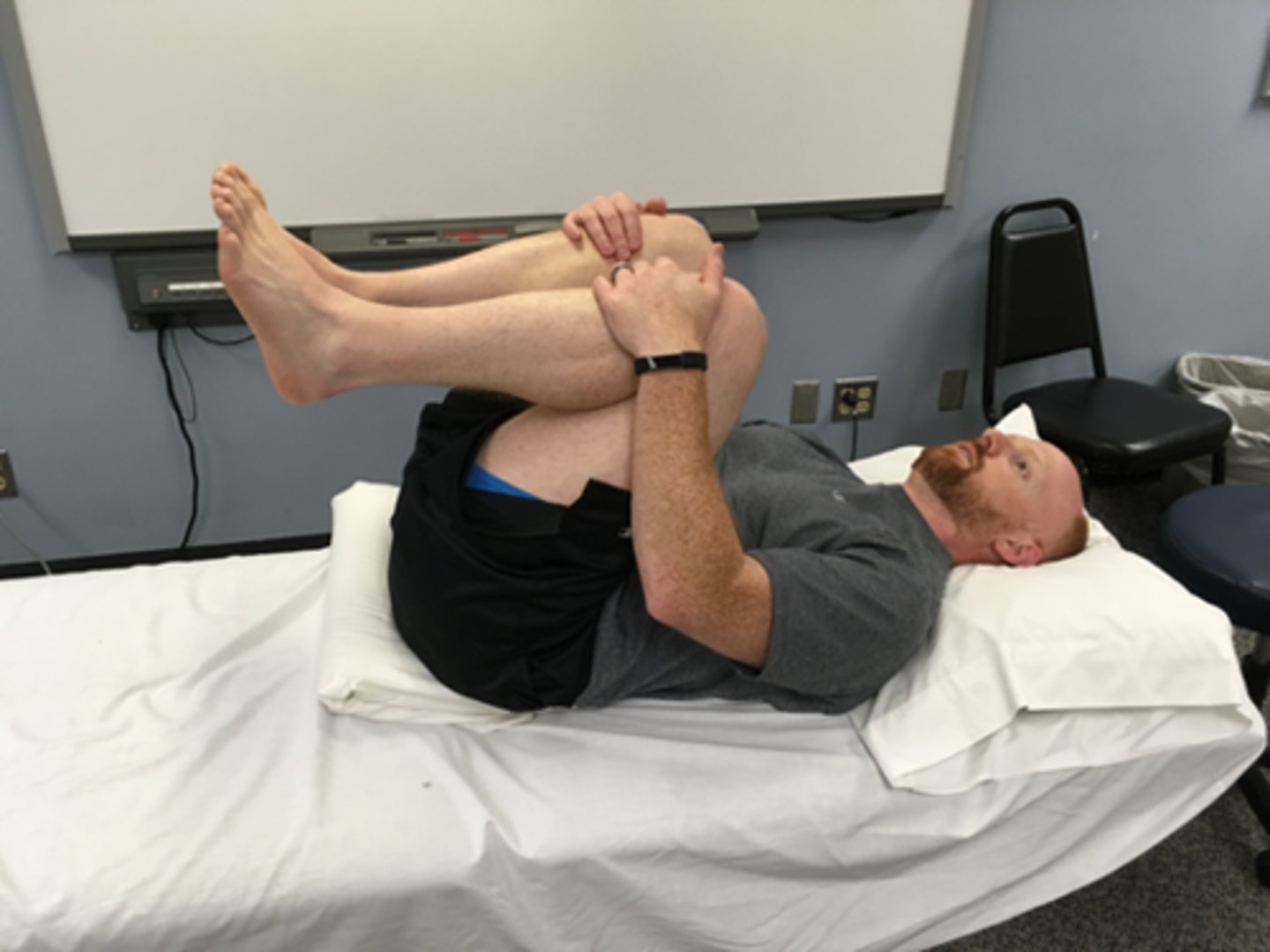 <p>flexion bias</p><p>may start with one leg, then both</p><p>extra ROM by abducting &amp; rotating hips out</p><p>head stays on plinth</p><p>should be passive, using patient’s arms, not abdominals</p><p>stretch to lumbar spine increased by using pillow under pelvis</p>