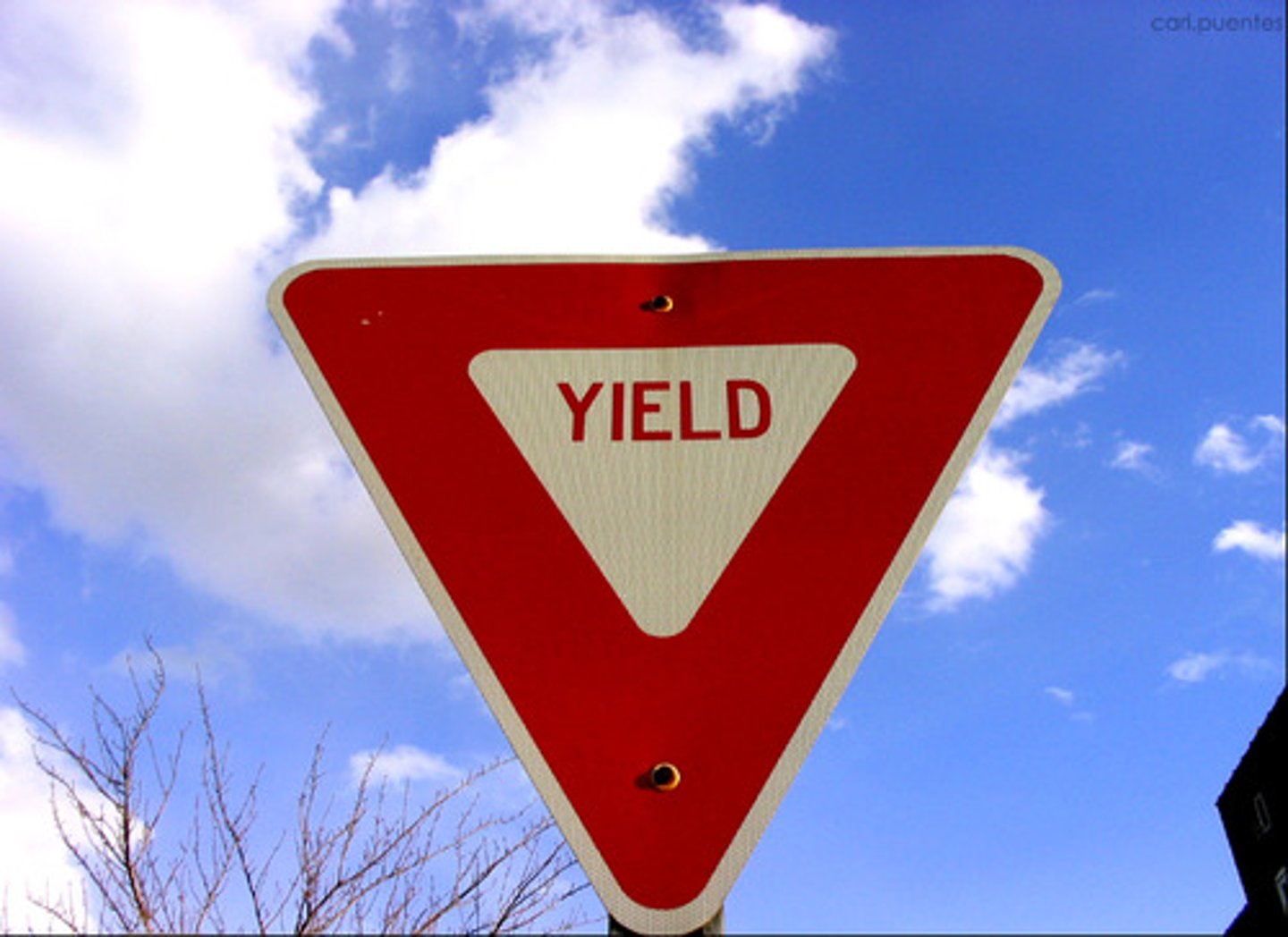 <p>A red and white equilateral triangle. This sign tells you that the road you are on joins with another road ahead. You should slow down or stop if necessary so that you can yield the right-of-way to vehicles on the other road.</p>