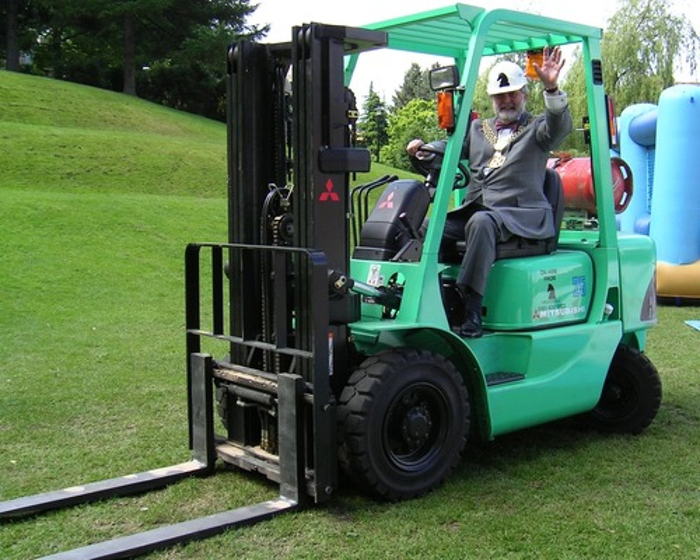 <p>a vehicle that uses two long metal bars at the front for lifting and moving heavy objects</p>