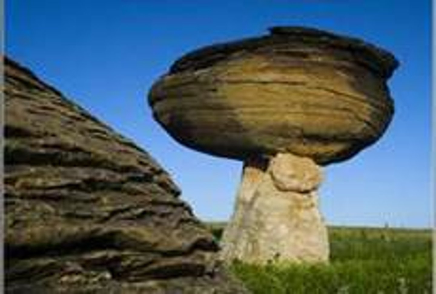 <p>A rock formed by wind erosion that carves away the bottom, leaving a cap-like top.</p>